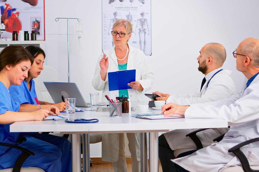 Doctors and nurses discussing research at a meeting